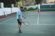 Casal sênior jogando tênis em quadra de tênis — Fotografia de Stock