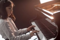 Entzückendes Schulmädchen spielt Klavier in der Musikschule — Stockfoto