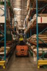 Arbeiter fährt Gabelstapler in Lagerhalle — Stockfoto