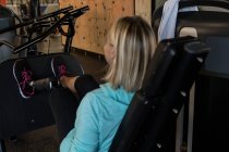 Mulher com deficiência exercitando-se na máquina no ginásio — Fotografia de Stock
