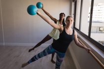 Two women performing barre exercise in fitness studio — Stock Photo