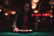 Frau arrangiert Snookerbälle im Dreiecksgestell in Nachtclub — Stockfoto
