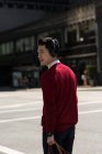Молодий чоловік слухає музику на навушниках під час перетину вулиці — стокове фото