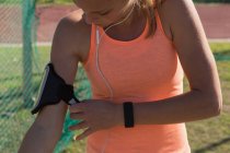Young female athlete wearing arm band — Stock Photo