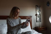 Donna che utilizza tablet digitale in camera da letto a casa — Foto stock