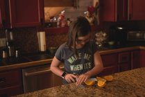Fille coupe la chaux douce dans la cuisine à la maison — Photo de stock