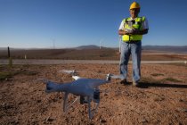 Ingeniero que controla un dron con un controlador en un parque eólico - foto de stock