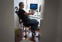 Homem preparando projeto arquitetônico no laptop em casa — Fotografia de Stock