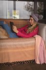 Девушка с собакой с помощью цифрового планшета в гостиной дома — стоковое фото