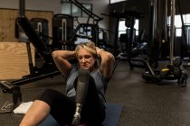 Donna disabile che esegue esercizio di stretching in palestra — Foto stock