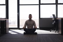 Uomo d'affari che esegue yoga in ufficio — Foto stock