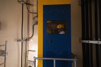 Engenheiro em pé dentro do elevador de serviço de uma turbina eólica — Fotografia de Stock