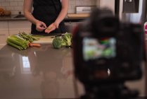 Frau bereitet Gemüse zu Hause in der Küche zu — Stockfoto