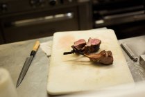 Carne em uma tábua de cortar na cozinha — Fotografia de Stock