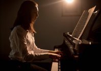 Seitenansicht einer Schülerin, die in der Musikschule Klavier spielt — Stockfoto