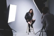 Modelo femenino posando para una sesión de fotos en un estudio fotográfico - foto de stock