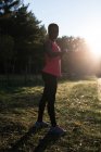 Athlète féminine vérifiant sa smartwatch dans la forêt — Photo de stock