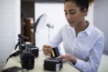 Female photographer removing reel from digital camera — Stock Photo
