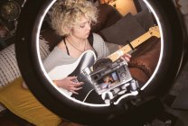 Donna blogger che suona la chitarra in salotto a casa — Foto stock