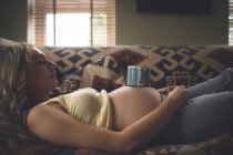 Mulher grávida dormindo na sala de estar em casa — Fotografia de Stock