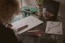 Giovane donna che disegna uno schizzo a casa — Foto stock