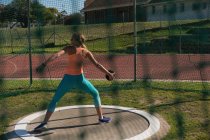 Female athlete practicing discus throw at sports venue — Stock Photo