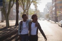 Gêmeos irmãos andando na rua da cidade em um dia ensolarado — Fotografia de Stock
