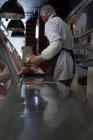 Butcher holding meat at counter in butcher shop — Stock Photo