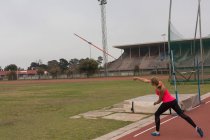 Athlète féminine pratiquant le lancer de javelot sur un site sportif — Photo de stock