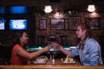 Romántica pareja brindando copa de vino en el club nocturno - foto de stock