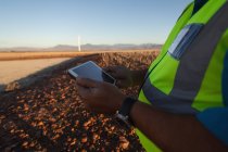 Mid section of engineer using a tablet at wind farm — Stock Photo