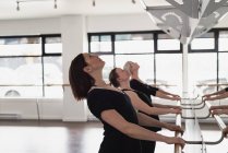 Group of women stretching holding the barre at the gym — Stock Photo