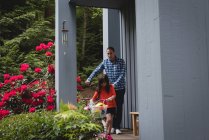 Padre e hija caminando juntos con bicicleta en el porche - foto de stock