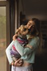 Adolescente segurando um cão em casa — Fotografia de Stock