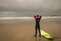 Surfista com prancha se preparando para surfar em um dia ensolarado — Fotografia de Stock