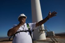 Un ingénieur parle sur un talkie-walkie dans un parc éolien — Photo de stock