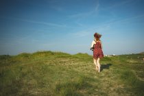 Rückansicht einer Frau, die auf den Hügel läuft — Stockfoto