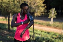 Sportler hört Musik von Smartphone-MP3-Player im Wald — Stockfoto