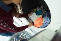 Gros plan de la femme faisant la lessive dans la laverie automatique — Photo de stock