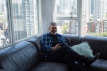 Человек, использующий цифровой планшет в гостиной на дому — стоковое фото