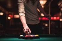 Mann hält Snookerball aus Dreiecksgestell in Nachtclub — Stockfoto