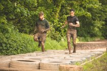 Fit men training over tyres obstacle course at boot camp — Stock Photo