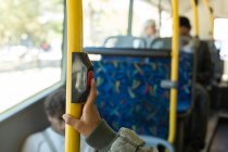 Person hand pressing button on pole while travelling in the bus — Stock Photo