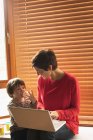 Мати і син сидять з ноутбуком на дому — стокове фото
