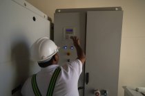 Ingeniero operando una máquina dentro del molino de viento en un parque eólico - foto de stock