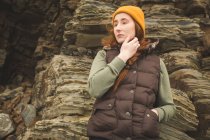 Thoughtful female hiker leaning against the rock — Stock Photo