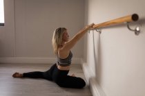 Woman performing barre exercise in fitness studio — Stock Photo