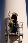 Engineers standing at the entrance of wind mill at a wind farm — Stock Photo