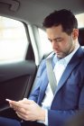 Смарт-бізнесмен, за допомогою мобільного телефону в автомобілі — стокове фото
