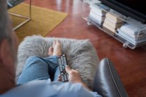 Man changing channels while watching television in living room at home — Stock Photo
